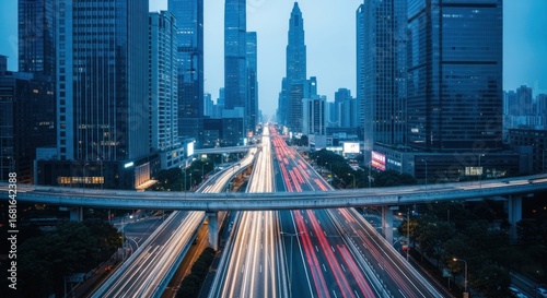 High-angle view of a modern city highway at twilight.  Busy traffic trails across a multi-level road system.  Skyscrapers line both sides of the thoroughfare
