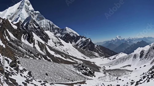 mountain with distinctive pyramidal shape, covered in layer of snow