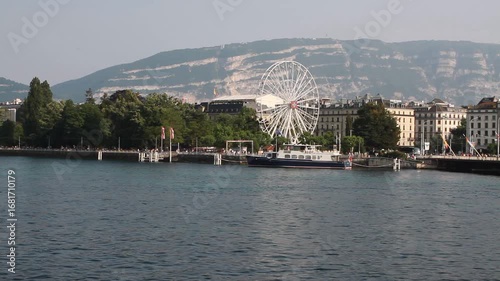 Lake, city and Ferris wheel on shore. Geneva, Switzerland