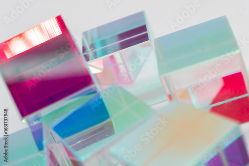 Randomly arranged transparent cubes with multicolored light effects in red, blue, green and purple, forming a vibrant abstract structure ideal for creative visuals, tech design or digital art themes
