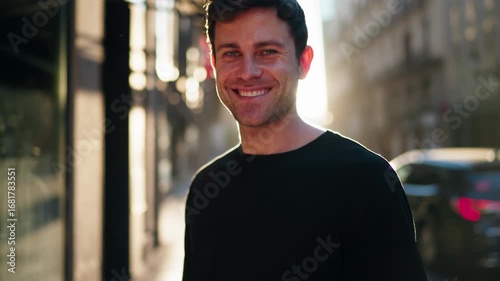 Close up portrait of smiling man in casual black shirt, standing outdoors in city. Concept of positivity, wellness, and modern lifestyle confidence.
