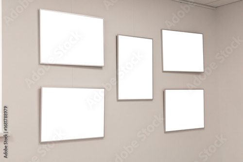 Five empty frames hang on a white wall in an art gallery, creating an open space for future exhibitions. The clean design allows for creativity and versatility in showcasing art