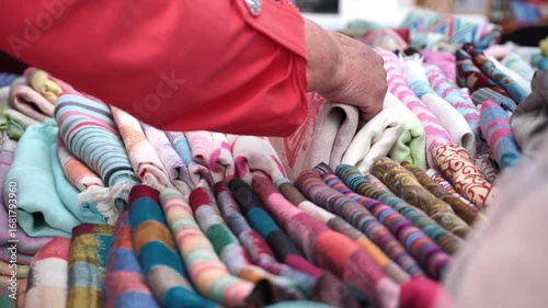 Hands holding pashminas in a street market stall in India