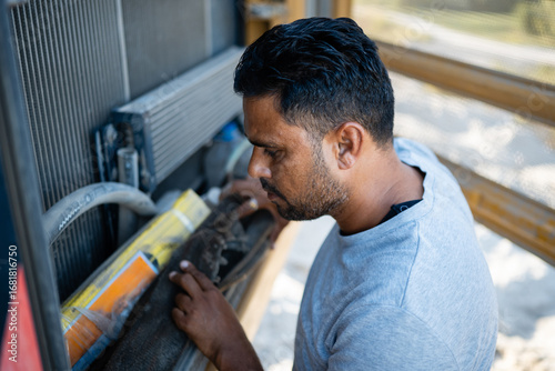 Quadro em tela Mechanic inspecting radiator of heavy duty vehicle during maintenance check