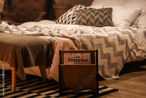 Magazine stand near bed wit...