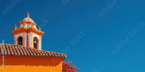 Colorful church tower rising against vibrant blue sky in seville