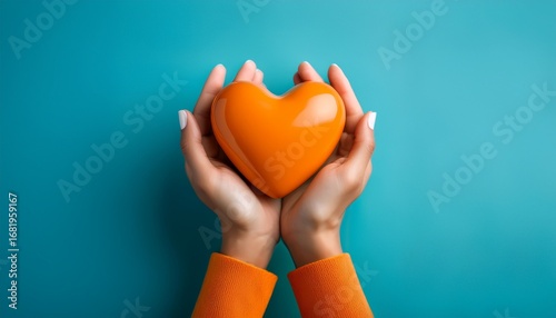 Wallpaper Mural hands holding an orange heart on a blue background as a symbol of volunteer appreciation and community support Torontodigital.ca