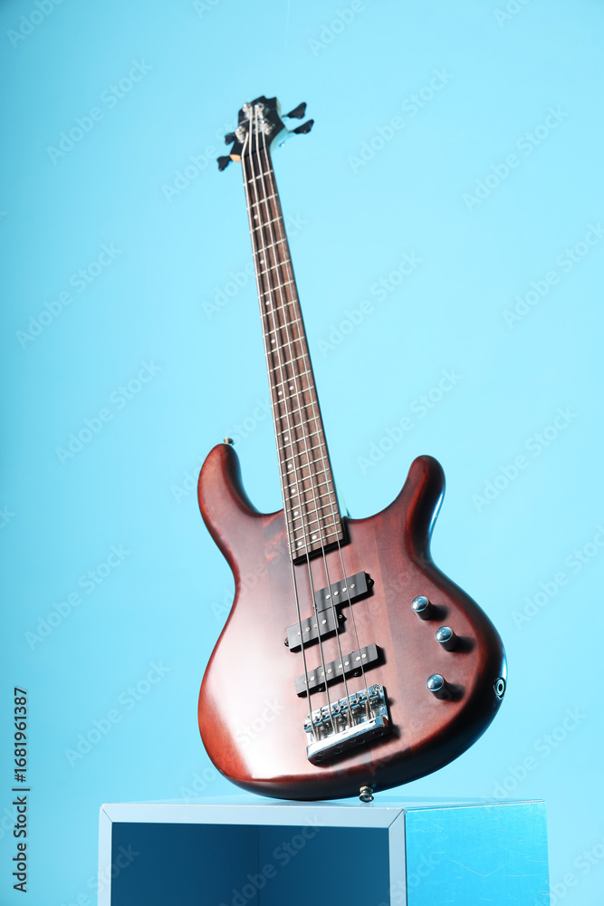 Fototapeta premium Decorative podium with modern electric guitar on blue background
