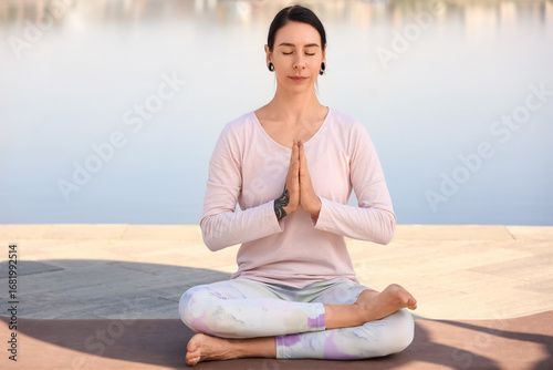 Young woman meditating on e...
