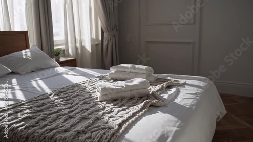 The habitual activities performed upon waking, depicted by set of white sleepwear neatly folded on blanket and bedspread