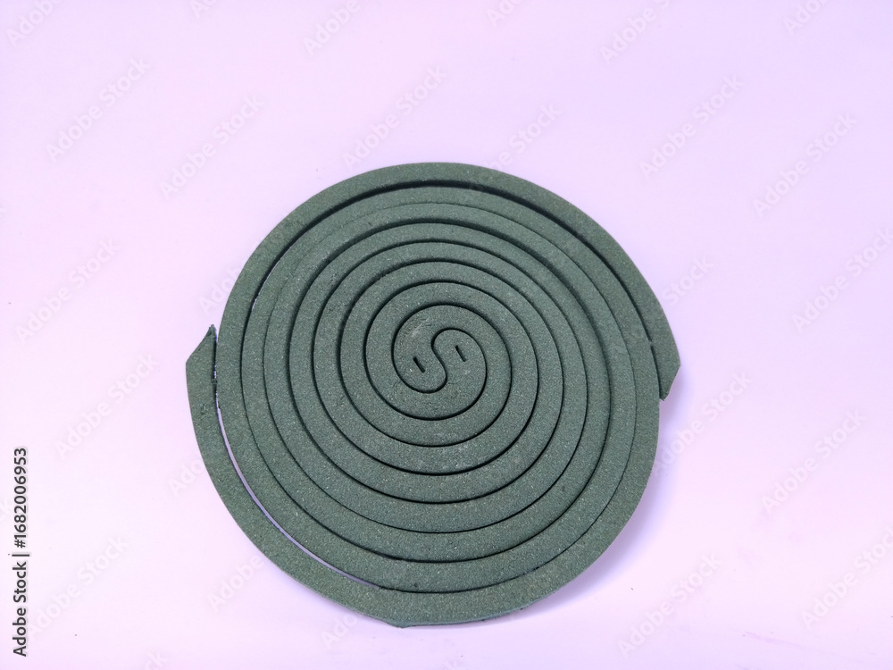 Fototapeta premium A green mosquito coil in a spiral shape placed on a plain white background.
