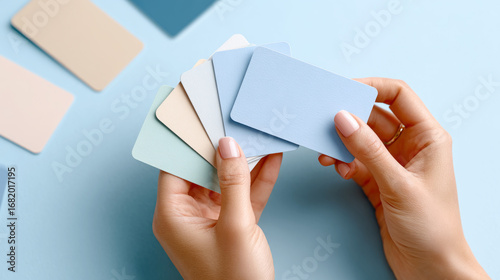 Flat lay of flashcards in hand on blue background for education and study concepts