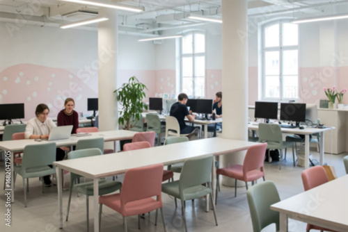 Blurred image of a Collaborative Office Space: Individuals Working at Desks with Computers in a Bright Area Featuring Large Windows and a City View. To be used as background