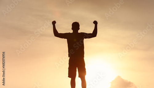 Photography silhouetted man stands with arms raised, showcasing triumph and freedom