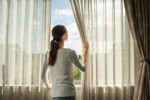 Woman Looking Out Window Through Curtains, Enjoying a Bright Sunlit Day, feelings of, tranquility, reflection Free Download Woman Looking Out Window Through Curtains, Enjoying a Bright Sunlit Day, feelings of, tranquility, reflection - GFXLoad
