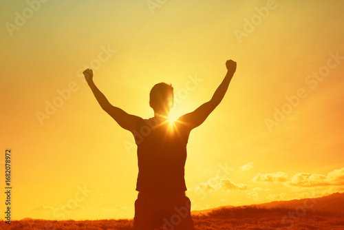 A person raises arms triumphantly against a radiant sunset, symbolizing success, positivity, and personal achievement. An inspiring visualization of determination, joy, and empowerment in a nature 