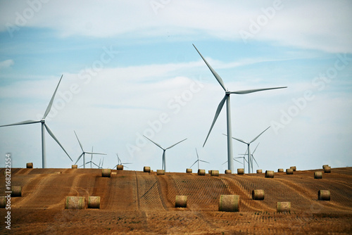 Tableau sur toile Wind Turbines and Hay Bales