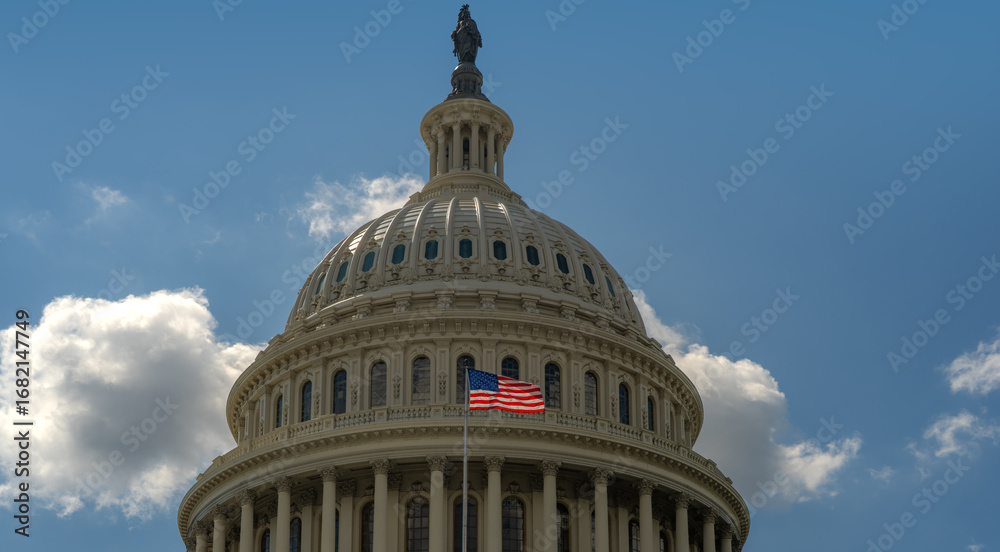 Obraz premium American flag waving on a flagpole against Congress and clear blue sky. US flag fluttering in the wind near Congress. USA, US waving flag, American flag.