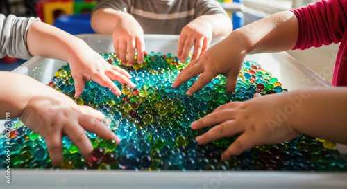 Kids Playing with Colorful Water Beads in White Container Under Bright Sunlight Education Development and Sensory Exploration Focus