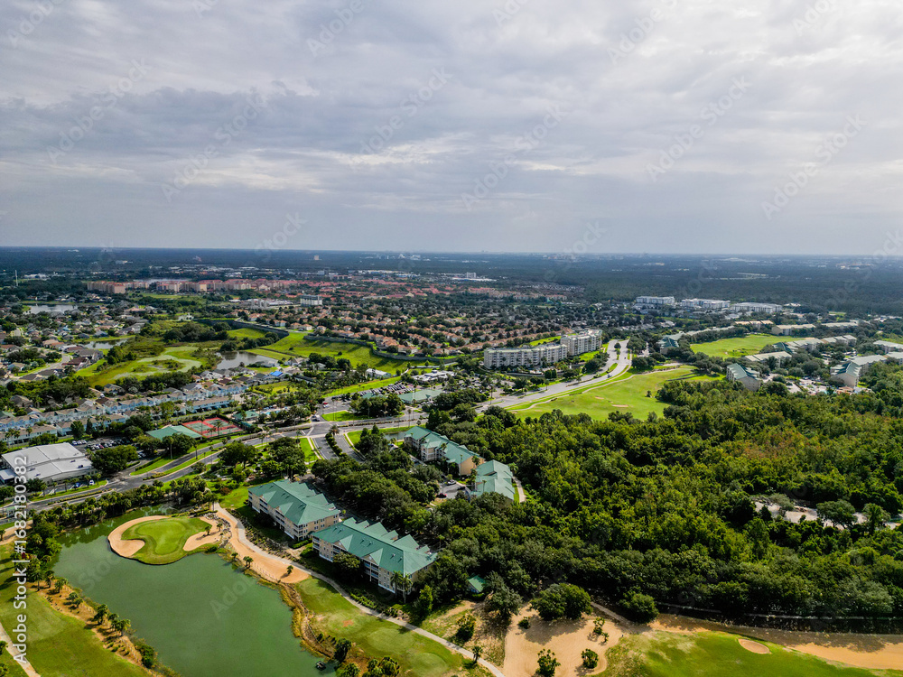 Obraz premium Aerial drone view of suburban homes in Kissimmee, Orlando, Florida, showing rooftops, streets, and green areas in a peaceful neighborhood setting.