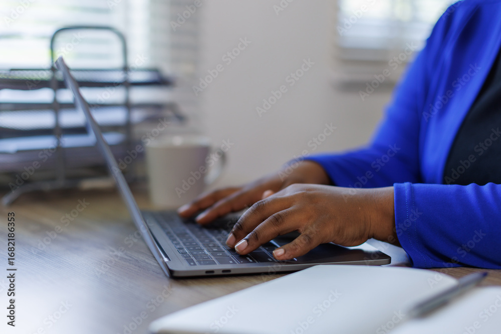 © David - African American business woman, A female secretary work on laptop Sitting at a Desk, reports to the workplace in the office, uses a computer © David - African American business woman, A female secretary work on laptop Sitting at a Desk, reports to the workplace in the office, uses a computer