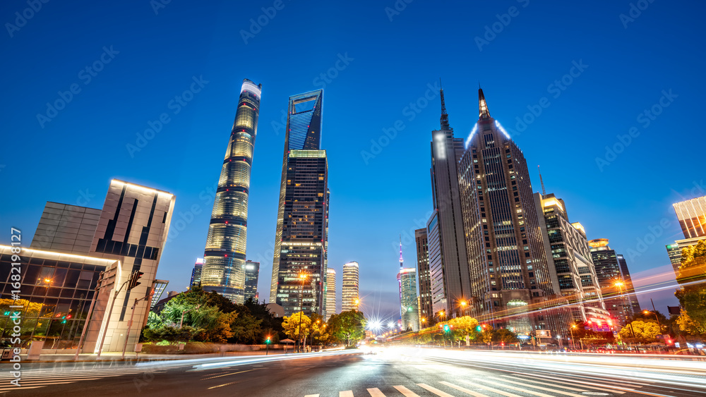 Fototapeta premium City skyline at dusk with modern skyscrapers and light trails