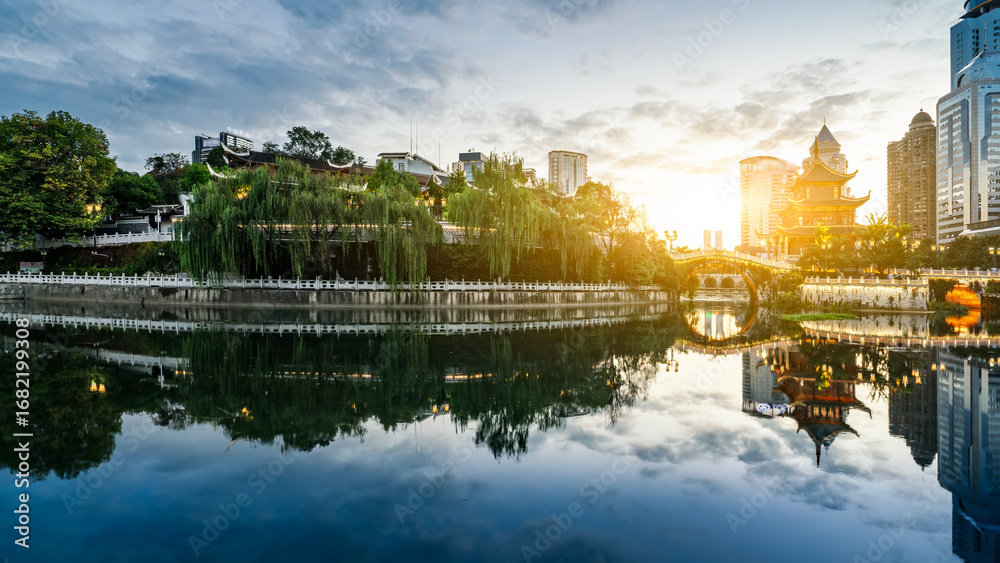 Naklejka premium Serene cityscape with calm water reflecting traditional architecture