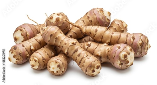 Fresh Jerusalem artichokes (sunchokes) piled on a white background, highlighting their unique texture and natural, earthy appearance. Ideal for healthy cooking concepts.