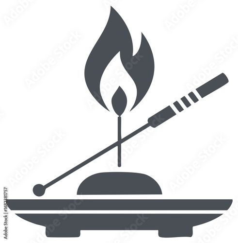 Incense stick lit by a small flame on a dish with crossed sticks