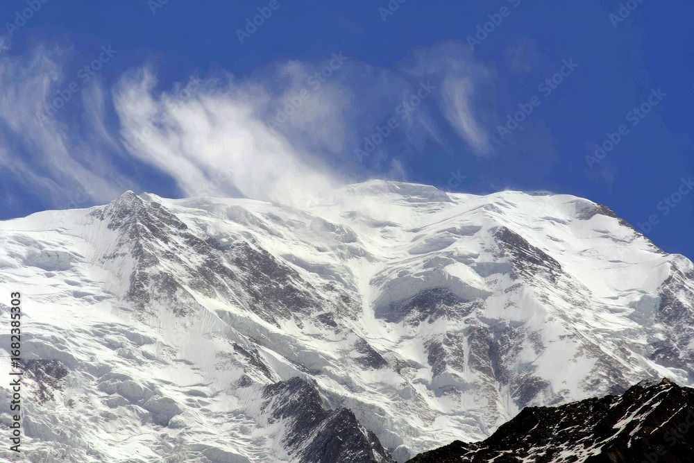 Obraz premium Snow-capped mountain peak under a vibrant blue sky with windswept clouds