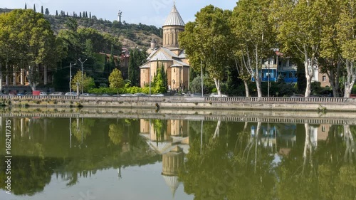 Historic Zion Cathedral, a Georgian Orthodox church, with reflections in the Kura River and traffic in Tbilisi