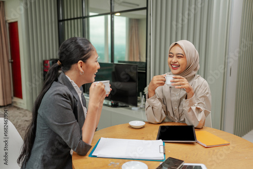 Fotografie Professional women enjoy coffee and meaningful conversation in a modern office s