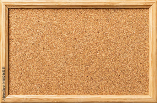 A light beige cork bulletin board in a light brown wooden frame