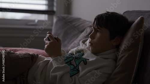 Boy playing video games on couch - medium shot