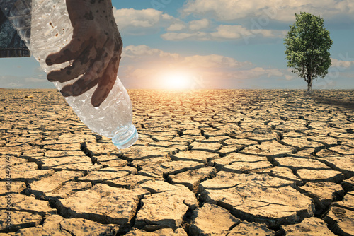 Photography Bottle of water in an empty hand, devoid of water in a hot, dry climate