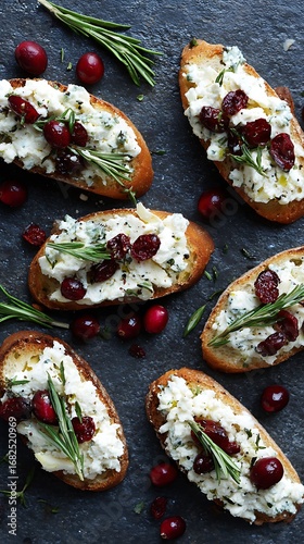 Bruschetta appetizers with cheese, rosemary, cranberries on dark surface