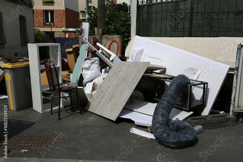 Dépôt sauvage dans la rue de planches et de détritus divers