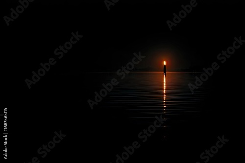 Single candle flame, reflected in still water, dark night