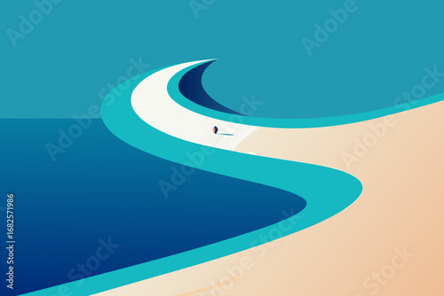 Lone figure stands on a curving pathway between the ocean and sandy beach under a clear blue sky