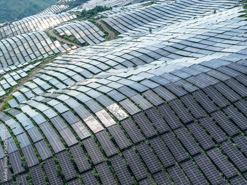 Large-scale solar power station with countless photovoltaic panels covering a vast mountainside for renewable energy production.