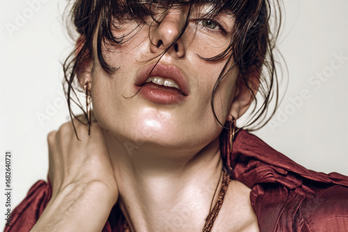 Female with wet hair and nodding body language shows close up portrait with natural skin and expressive lips in soft lighting