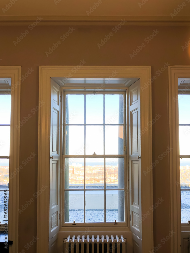 Fototapeta premium A window with a view of the city. The window is open. There is a radiator in front of the window