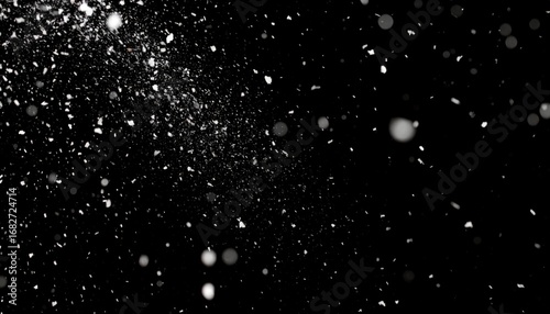 A blizzard of white particles scatters across a black background. Some are blurred spheres, others defined snowflakes, suggesting depth and motion
