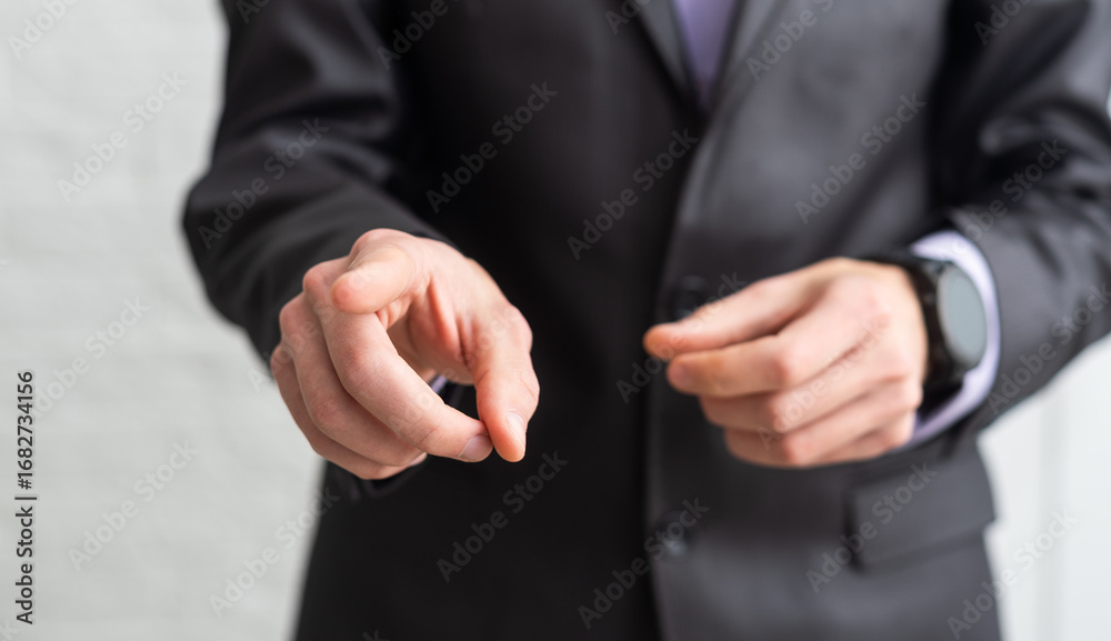 Fototapeta premium Handsome businessman in a suit and tie pointing his finger with isolated white background.