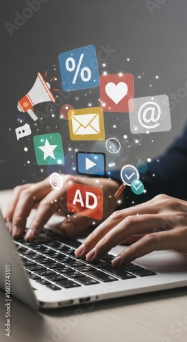 Hands typing on laptop with digital marketing icons floating above technology social media