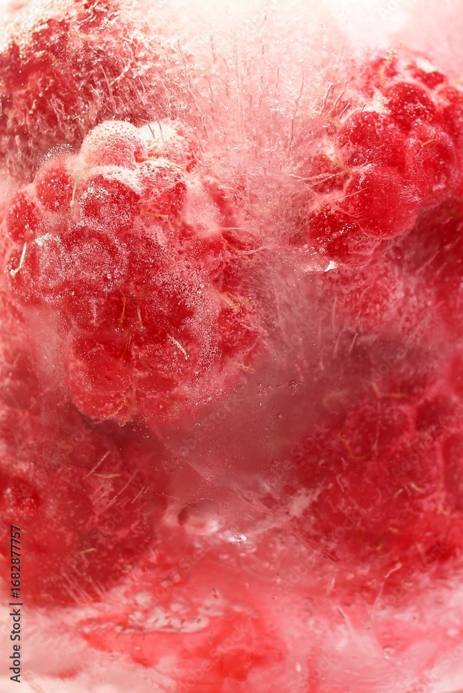 Obraz premium Frozen Raspberry in Ice, close up. Refreshing and Vibrant Background for Healthy Summer Food.