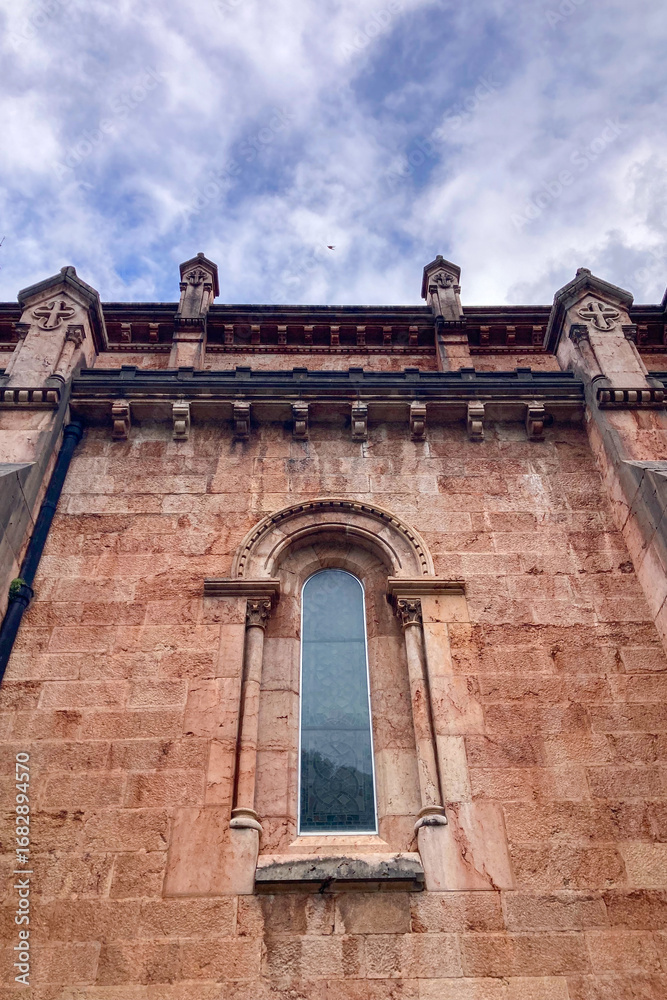 Obraz premium COVADONGA, SPAIN - APRIL 6, 2025: Covadonga in Asturias is a historic mountain village known for its sacred cave, basilica, and stunning natural surroundings.
