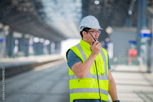 Construction engineer inspecting railway track industrial documents in hand while examining rail structure closely construction, safety and professional project management transportation development.