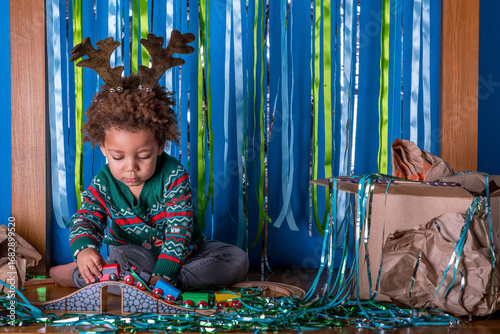 Obraz na plátne Toddler plays with a train set at a Christmas party