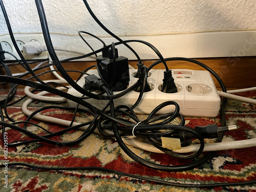 Bild auf Leinwand Lío de cables eléctricos enredados y enchufados en regleta base multicontacto so